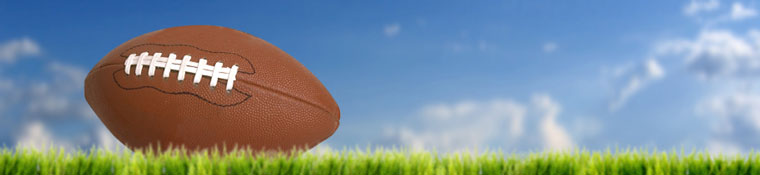 Photo of football against grass and sky